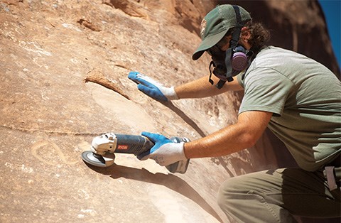 ranger qui enlève un graffiti à l'aide d'une meuleuse